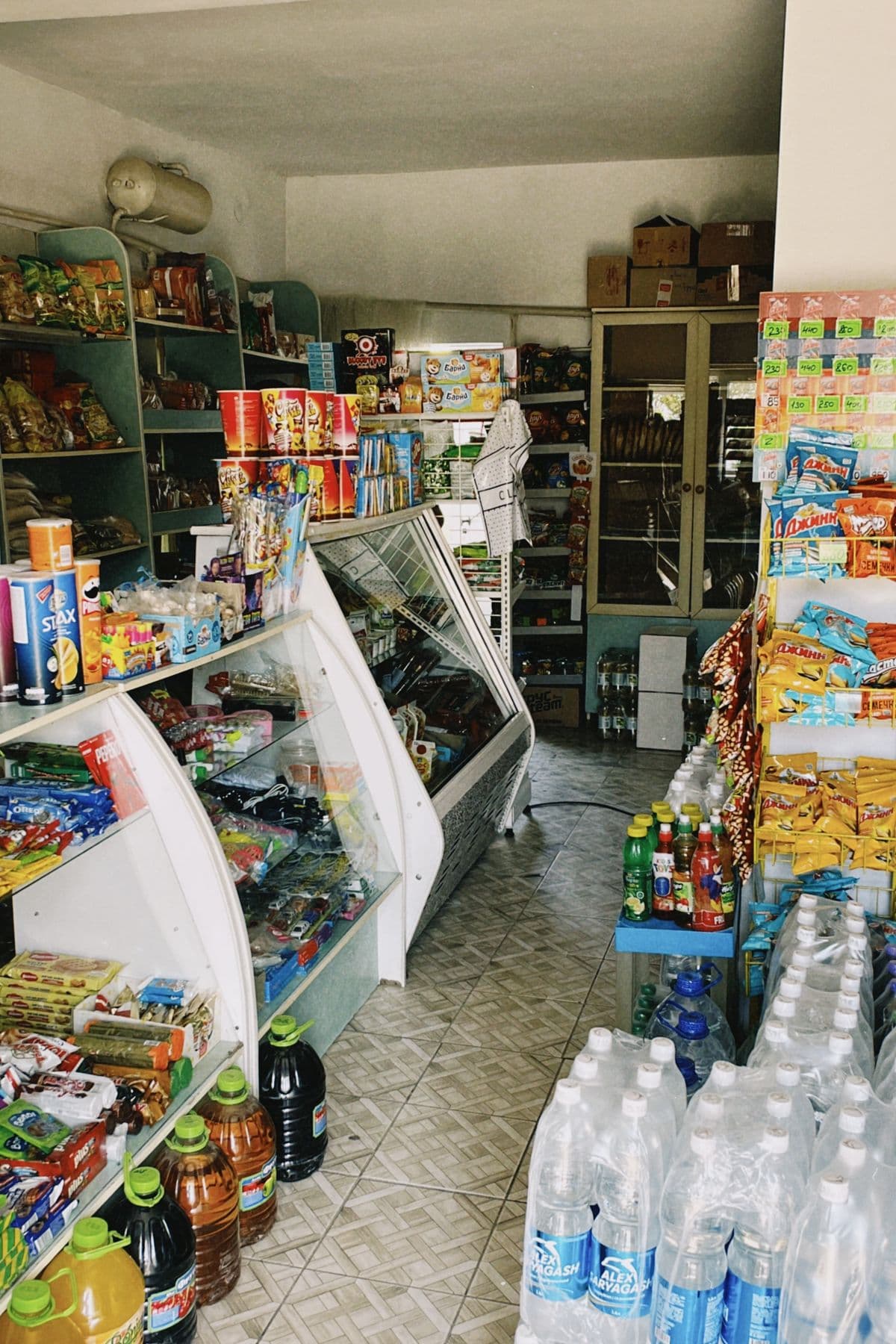 Inside a real small shop, shelves stocked with everyday products